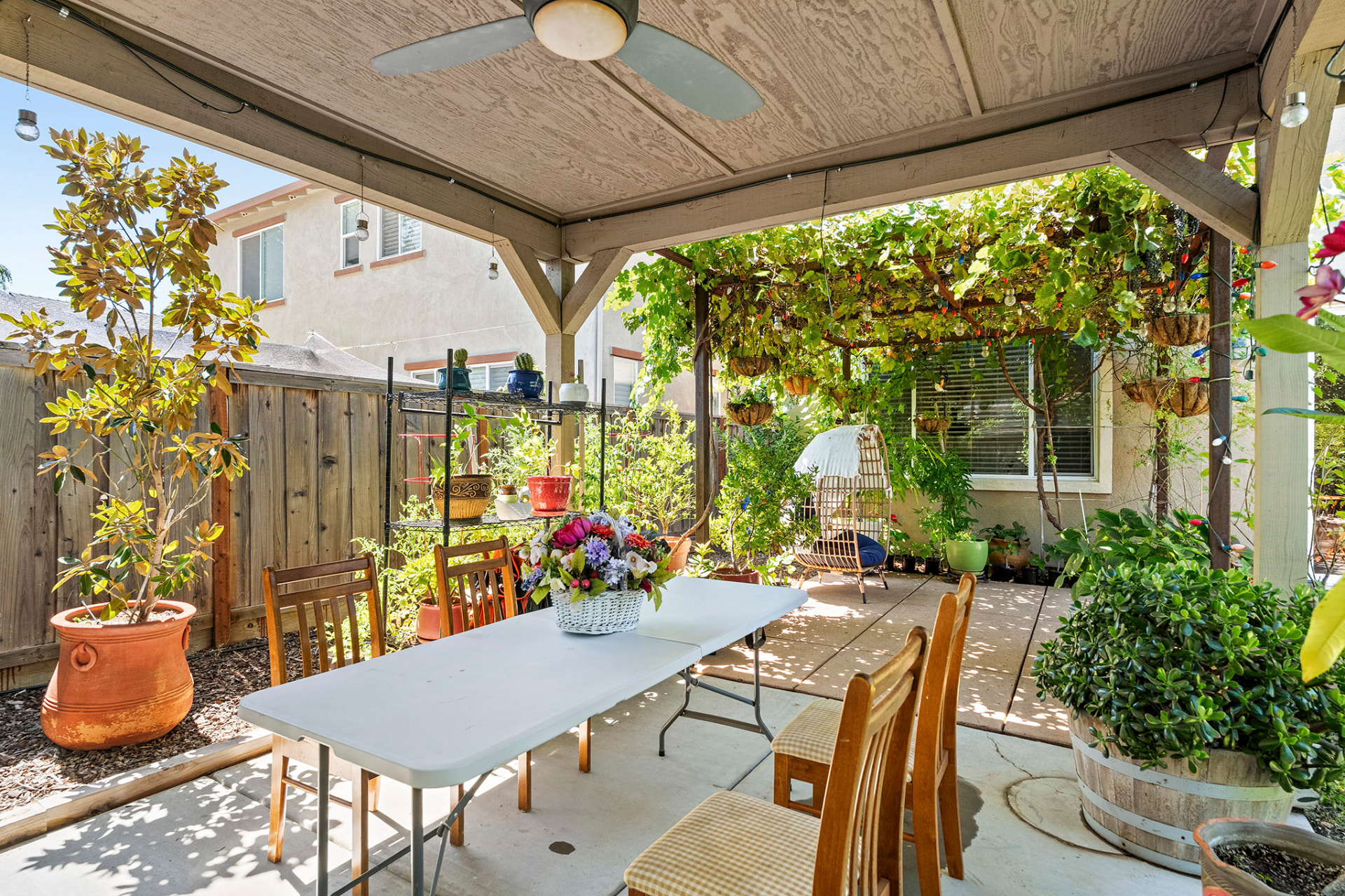 Covered patio with comfortable outdoor furniture beside the backyard