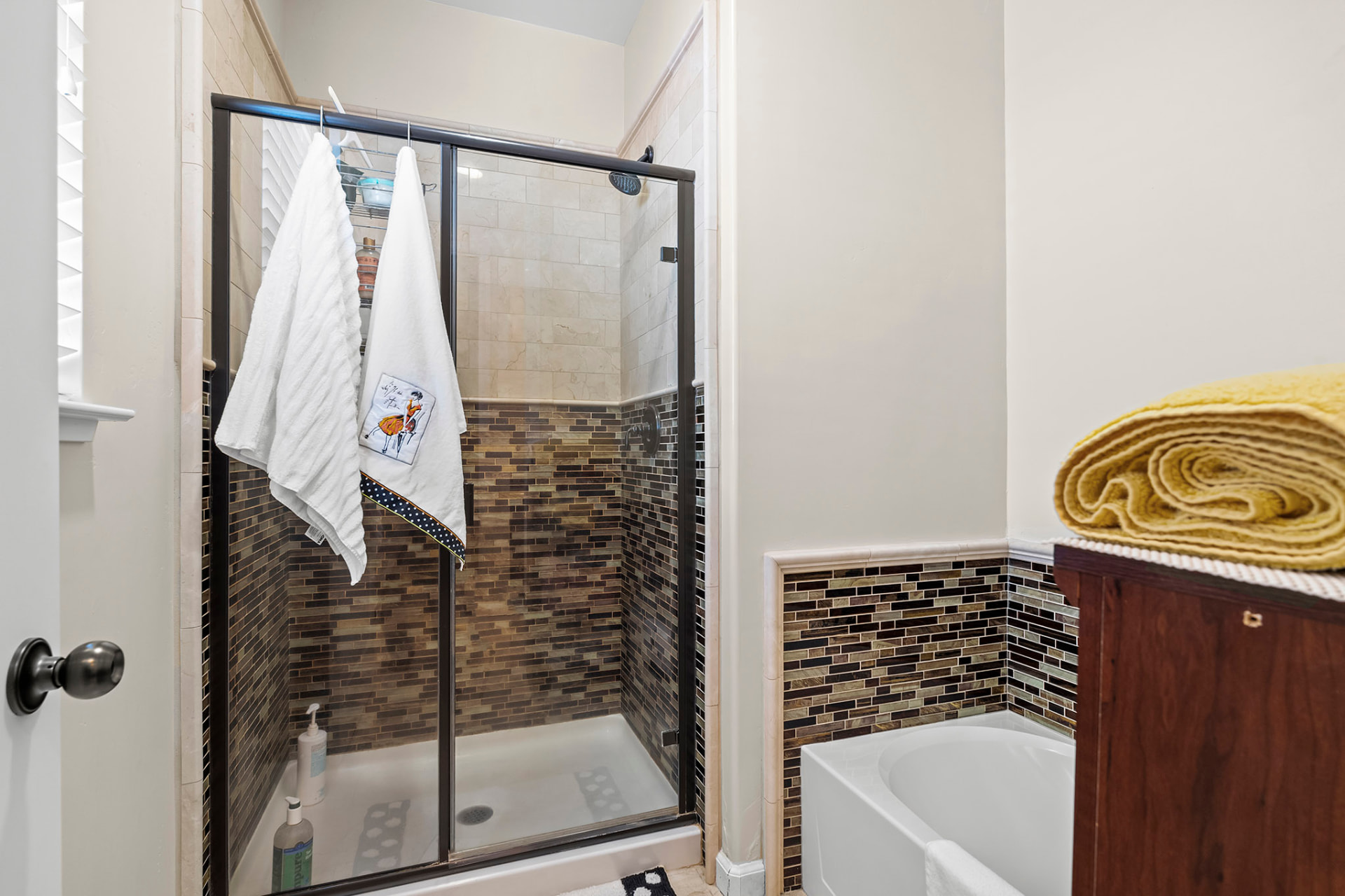 Tiled walk-in shower and soaking tub in the second full bath