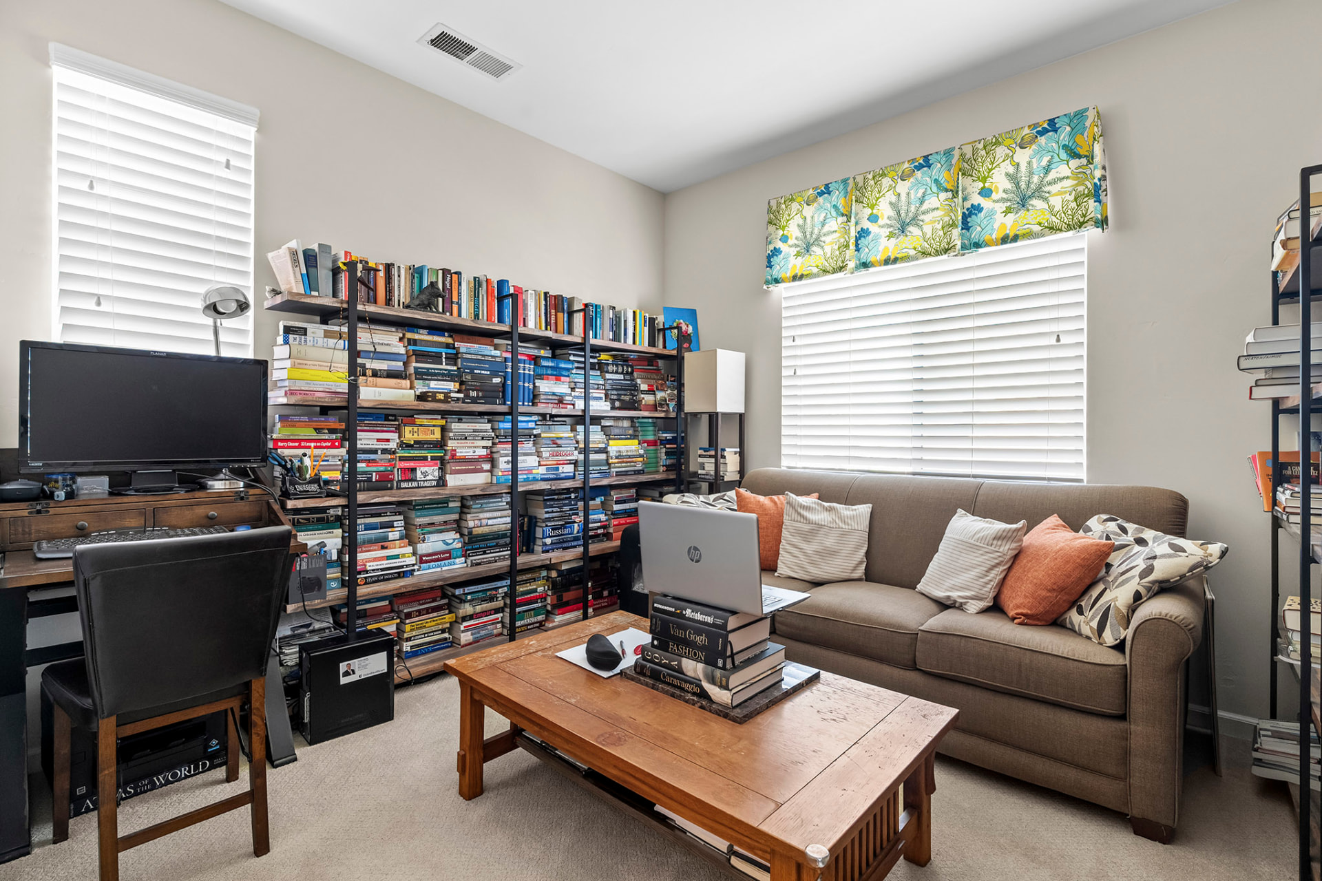 Bedroom used as a home office with built-in shelving, desk, and sofa