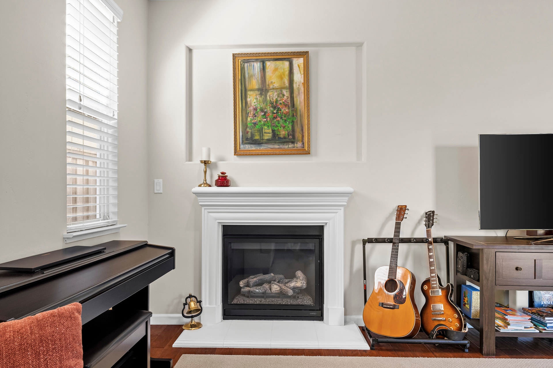 Family room fireplace with a white mantel and recessed art niche