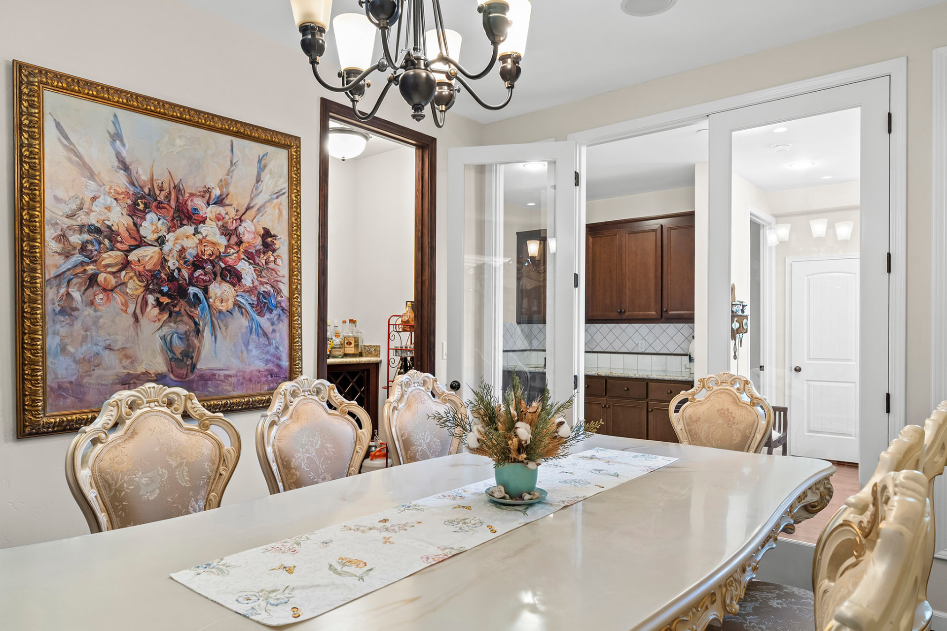 Dining room seating for eight with a butler's pantry and wine storage beyond