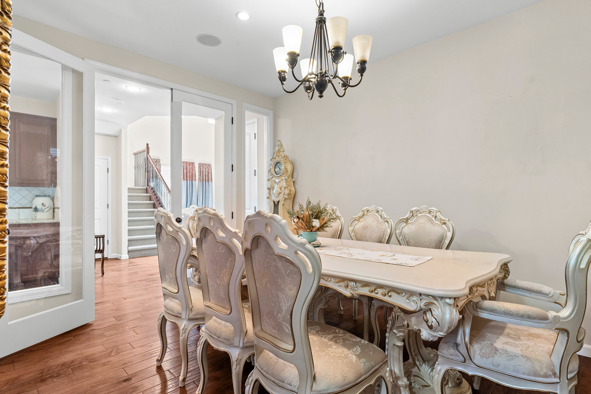 Formal dining room with a chandelier, hardwood floors, and French doors to the kitchen