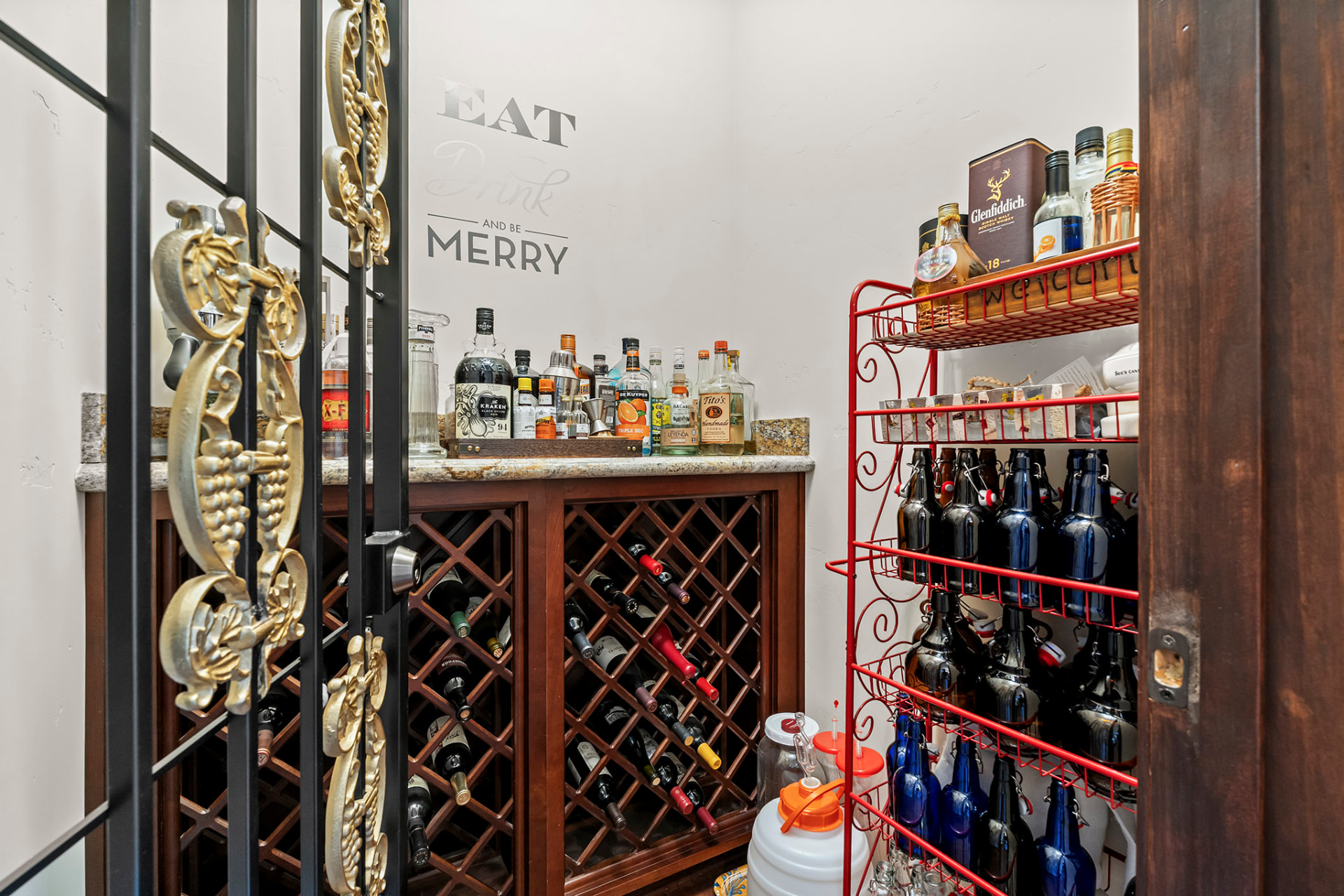 Walk-in wine room with a diamond-bin wine rack, granite-topped bar, and wrought iron gate