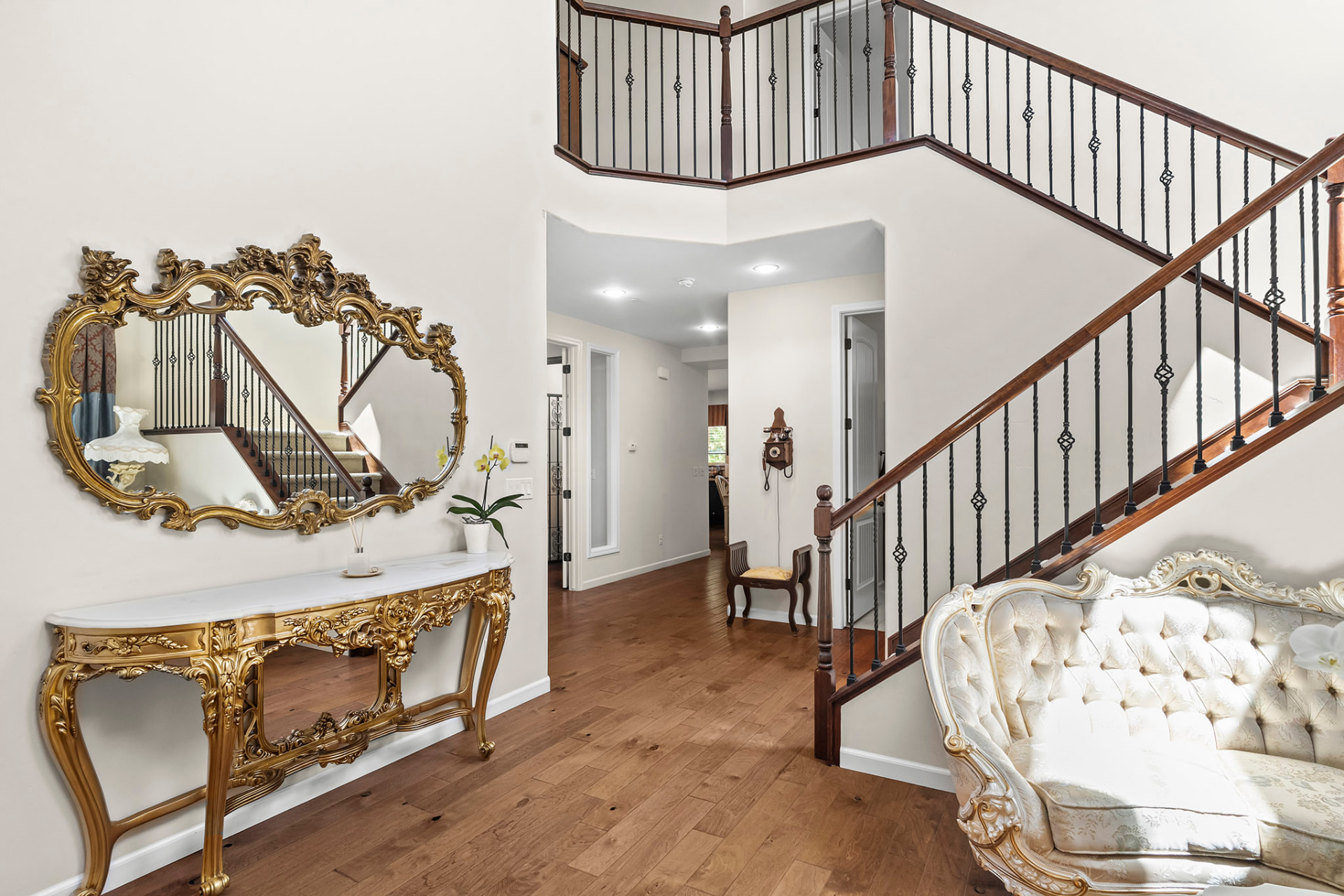 Two-story foyer with hardwood floors opening to the staircase and hallway